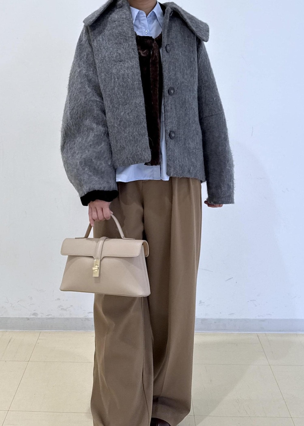 ベージュ系のショルダーバッグ、ブラウン系のブーツ、ブラウン系のTシャツ/カットソーを着用したレディースの秋コーディネートの4枚目の写真