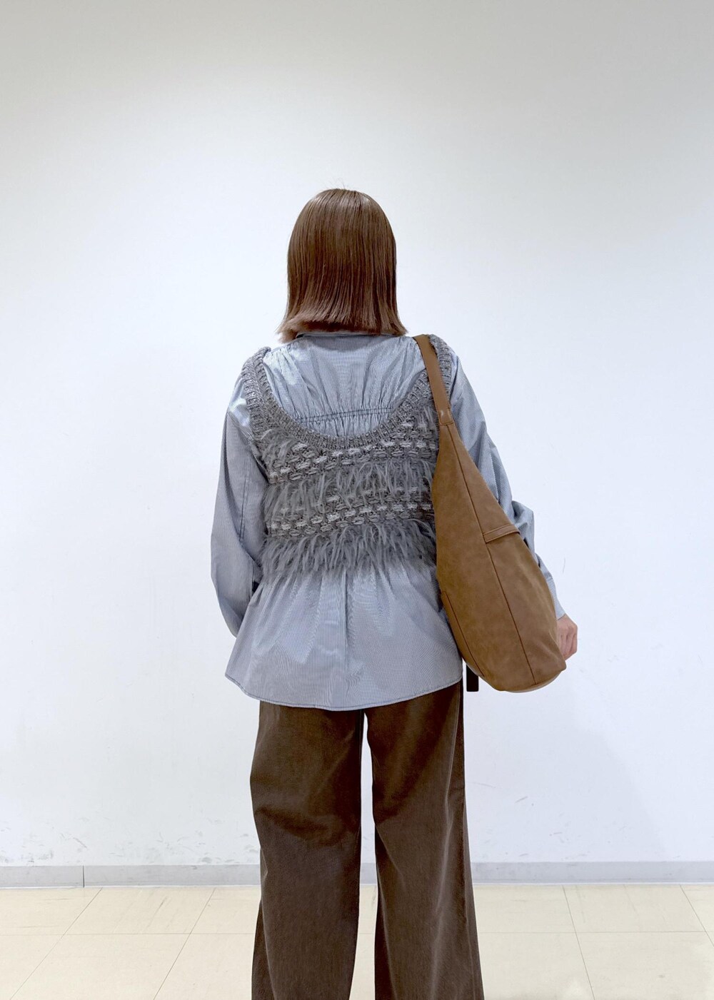 ブラウン系のショルダーバッグ、ブラウン系のデニムパンツ、ブルー系のシャツ/ブラウスを着用したレディースの秋コーディネートの8枚目の写真