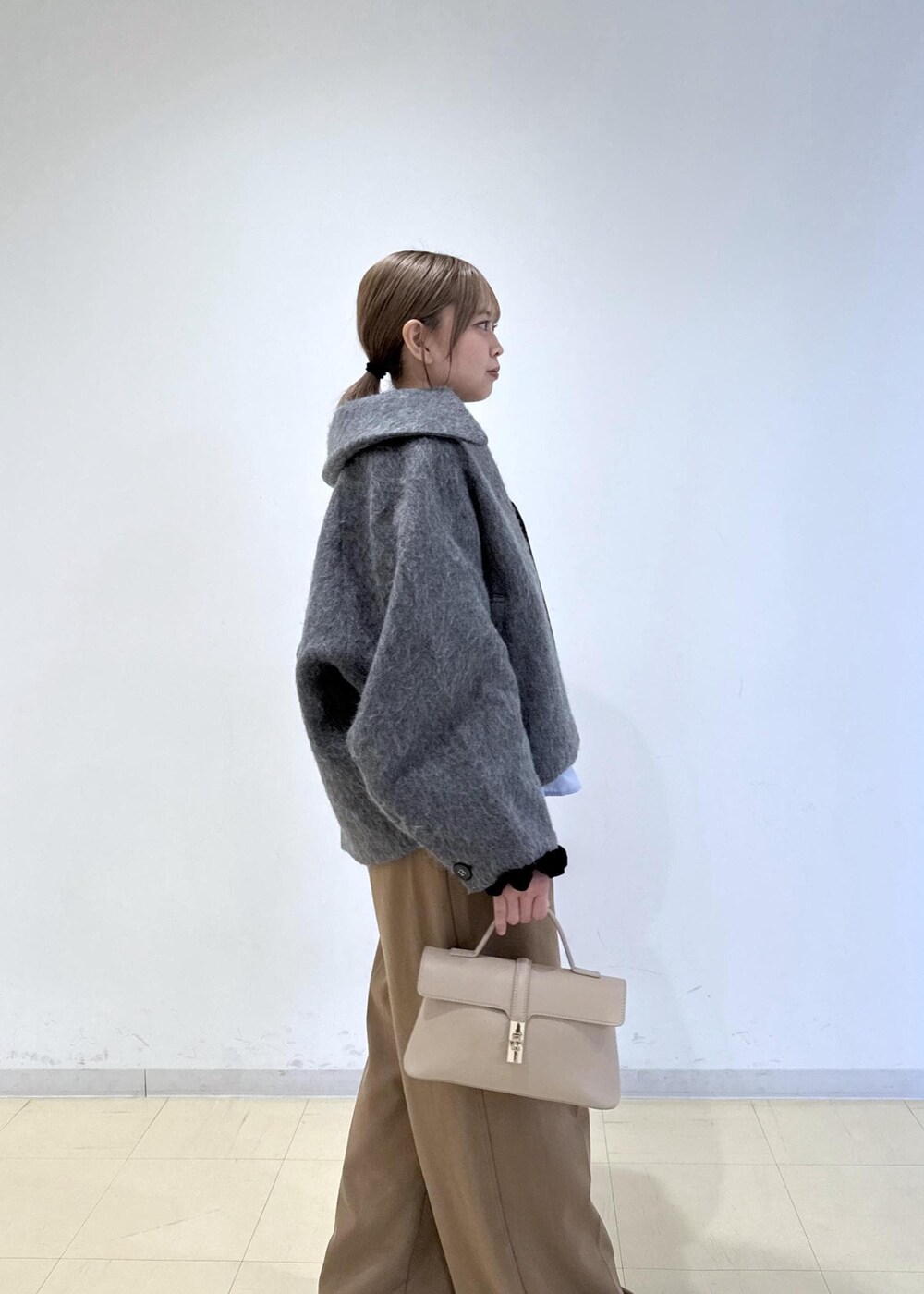 ベージュ系のショルダーバッグ、ブラウン系のブーツ、ブラウン系のTシャツ/カットソーを着用したレディースの秋コーディネートの8枚目の写真