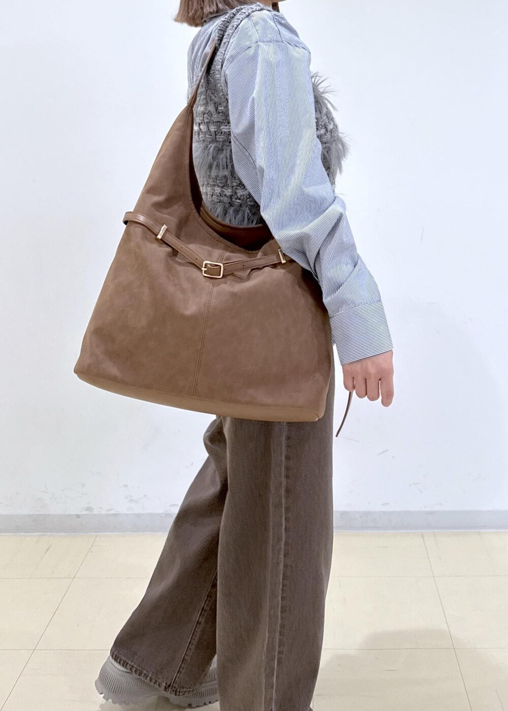 ブラウン系のショルダーバッグ、ブラウン系のデニムパンツ、ブルー系のシャツ/ブラウスを着用したレディースの秋コーディネートの7枚目の写真