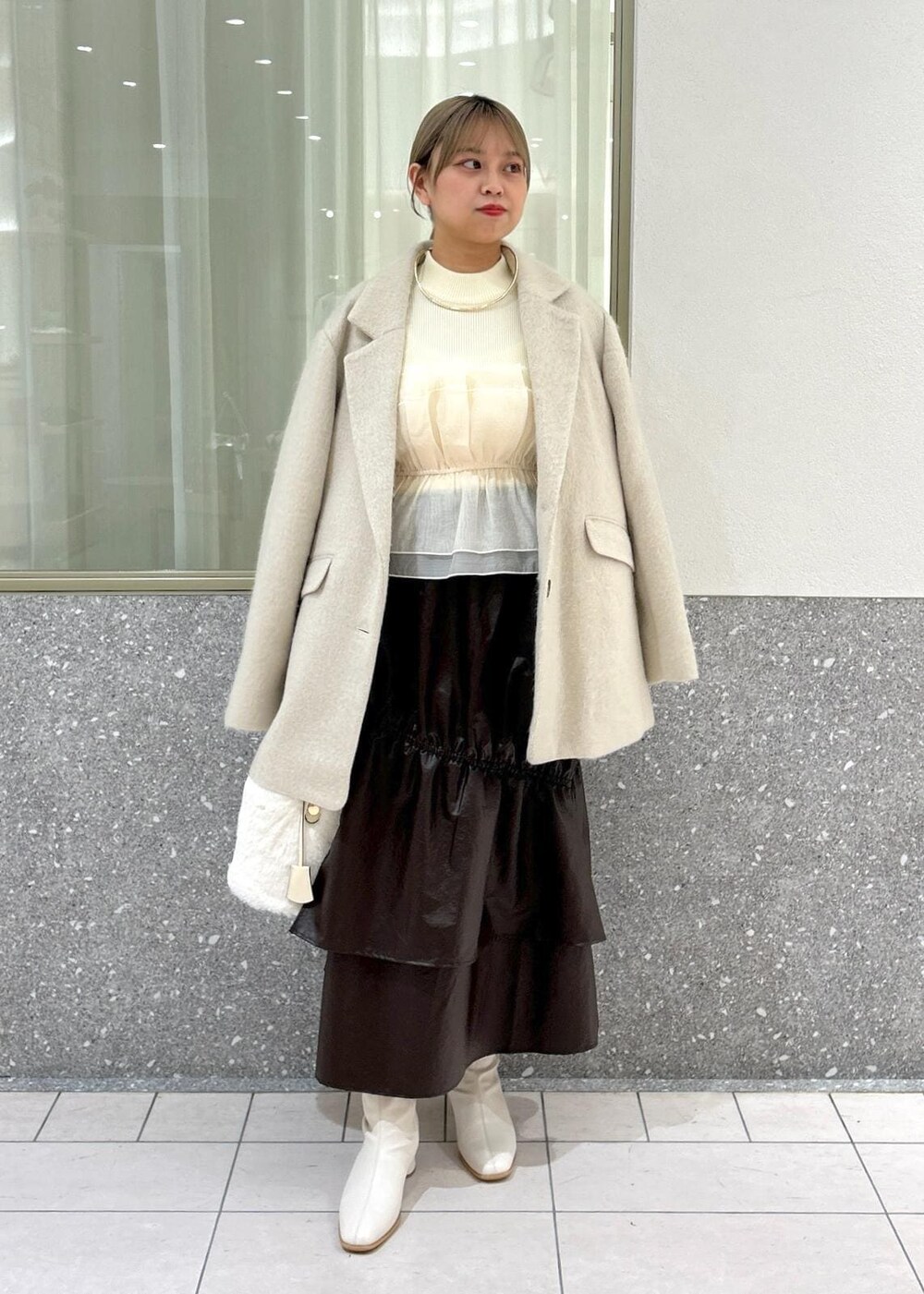 ホワイト系のブーツ、ベージュ系のスカート、ホワイト系のニット/セーターを着用したレディースの秋コーディネートの5枚目の写真