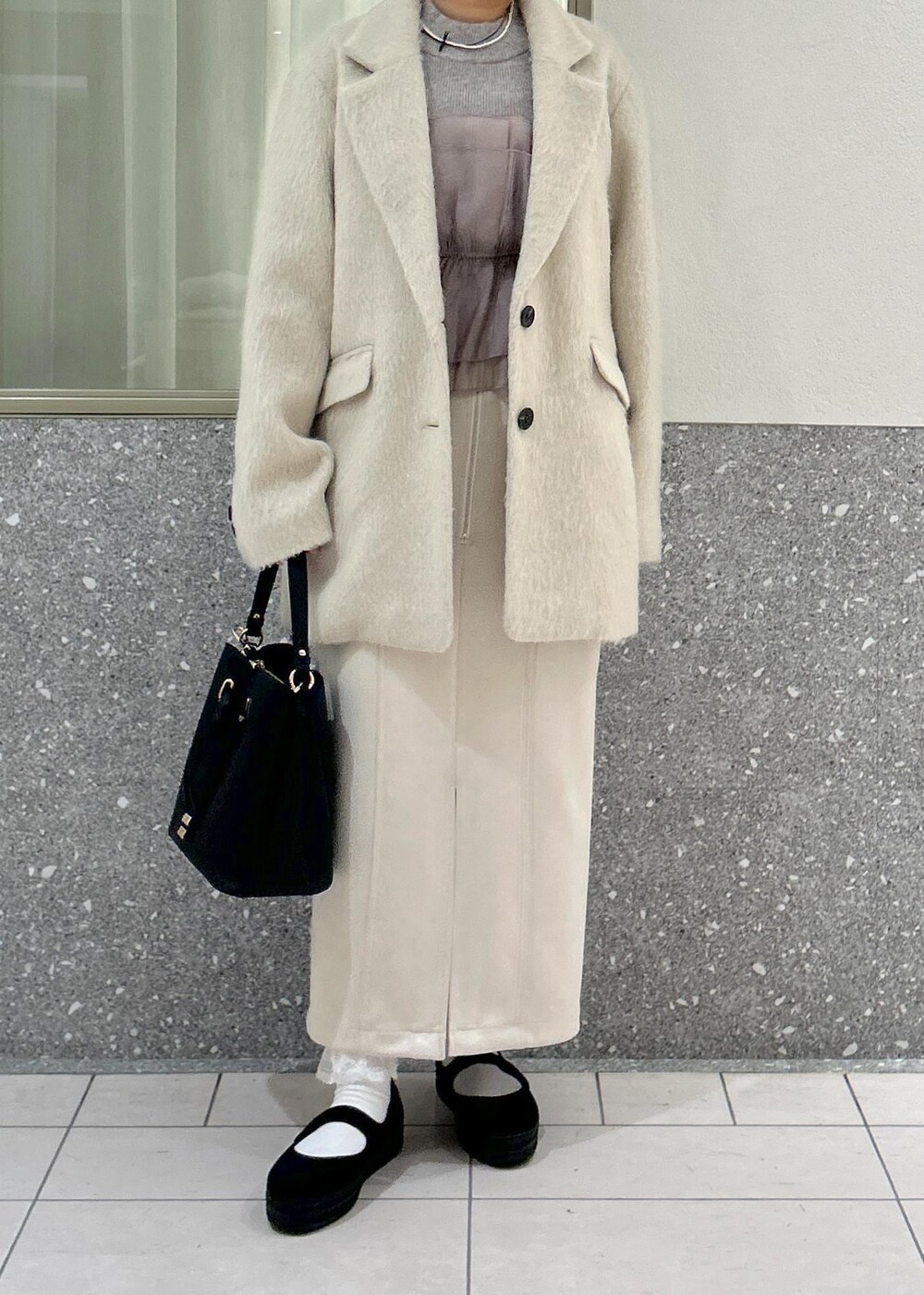 ベージュ系のスカート、グレー系のニット/セーター、ブラウン系のその他アウターを着用したレディースの冬コーディネートの8枚目の写真