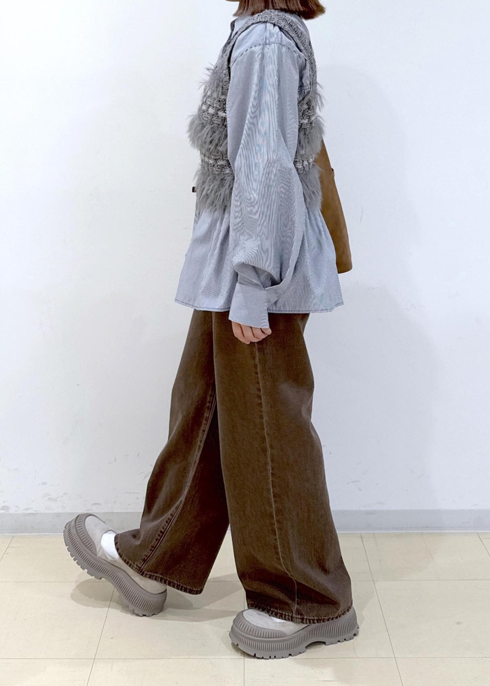 ブラウン系のショルダーバッグ、ブラウン系のデニムパンツ、ブルー系のシャツ/ブラウスを着用したレディースの秋コーディネートの5枚目の写真