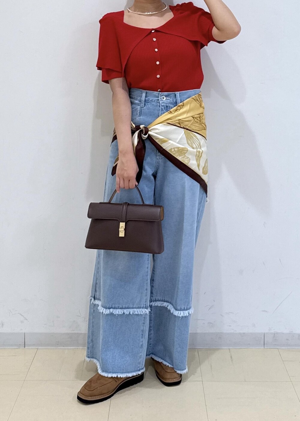 ブラウン系のショルダーバッグ、ベージュ系のローファー、レッド系のニット/セーターを着用したレディースの秋コーディネートの2枚目の写真