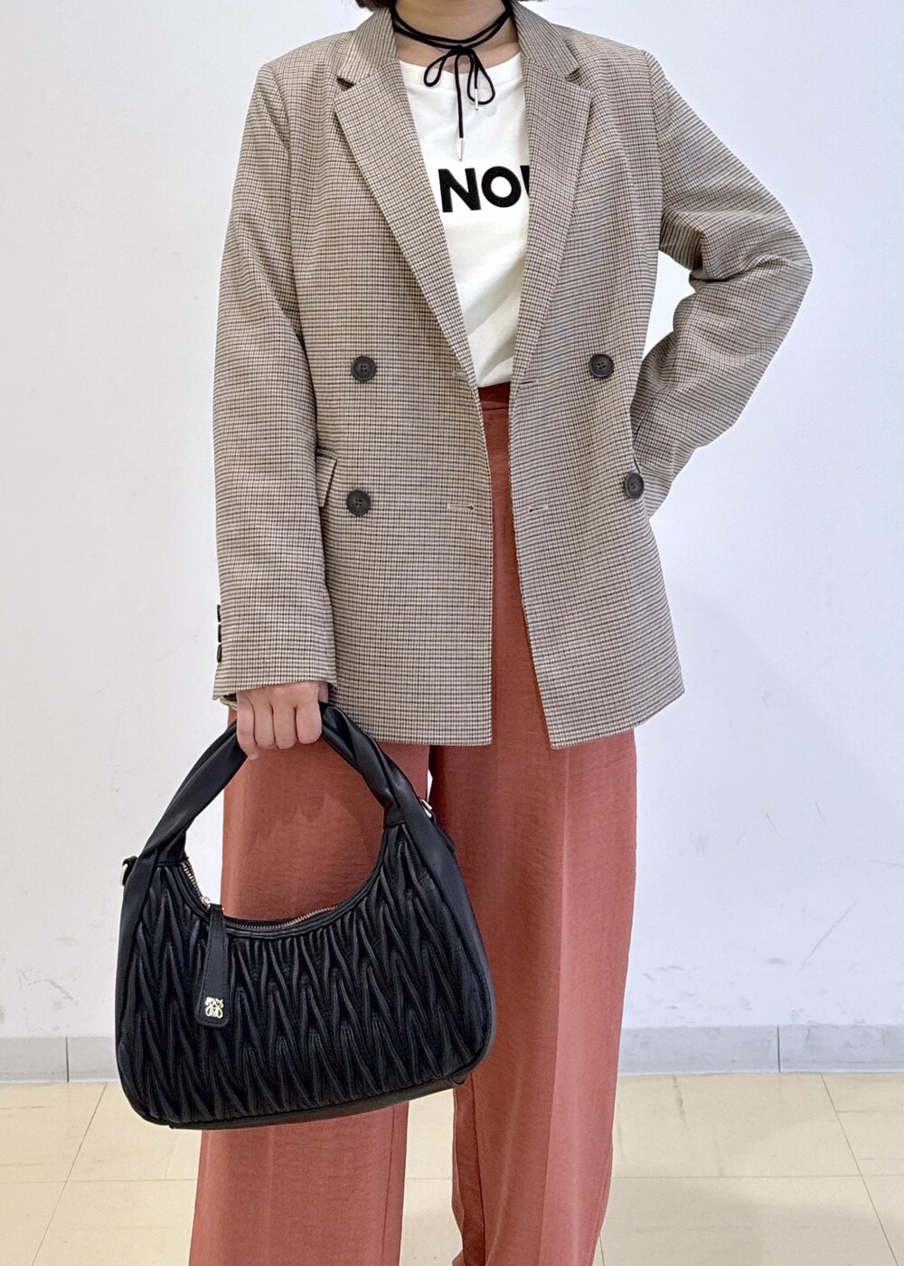 オレンジ系のスラックス、ベージュ系のテーラードジャケット、ホワイト系のTシャツ/カットソーを着用したレディースの秋コーディネートの6枚目の写真