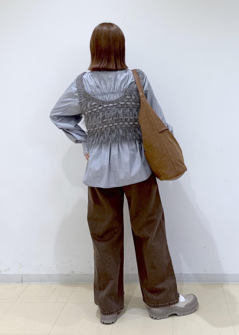 ブラウン系のショルダーバッグ、ブラウン系のデニムパンツ、ブルー系のシャツ/ブラウスを着用したレディースの秋コーディネートの4枚目の写真