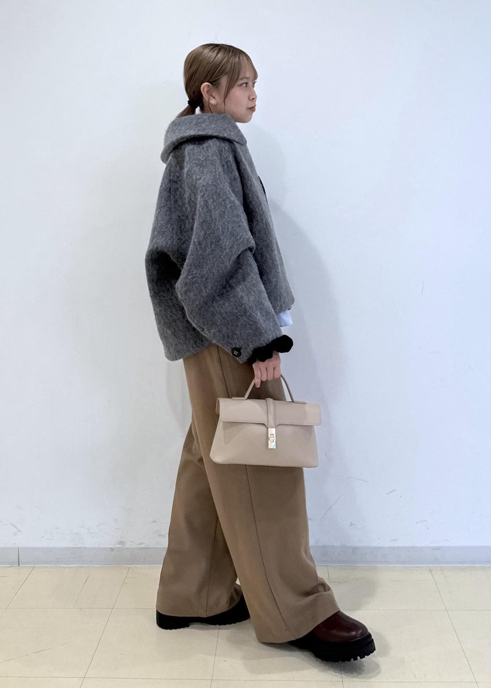 ベージュ系のショルダーバッグ、ブラウン系のブーツ、ブラウン系のTシャツ/カットソーを着用したレディースの秋コーディネートの2枚目の写真