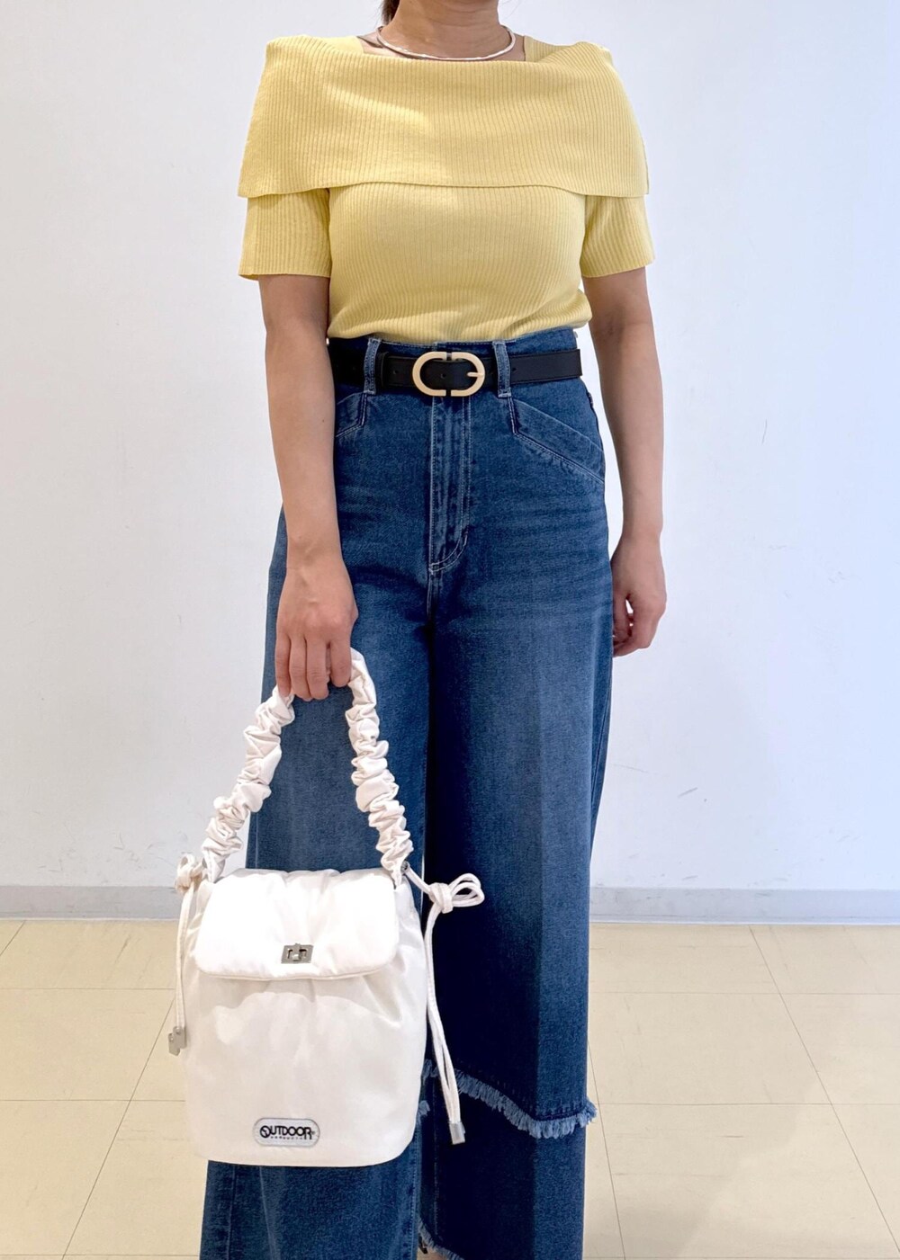 ブラック系のサンダル、ブルー系のデニムパンツ、イエロー系のニット/セーターを着用したレディースの夏コーディネートの6枚目の写真