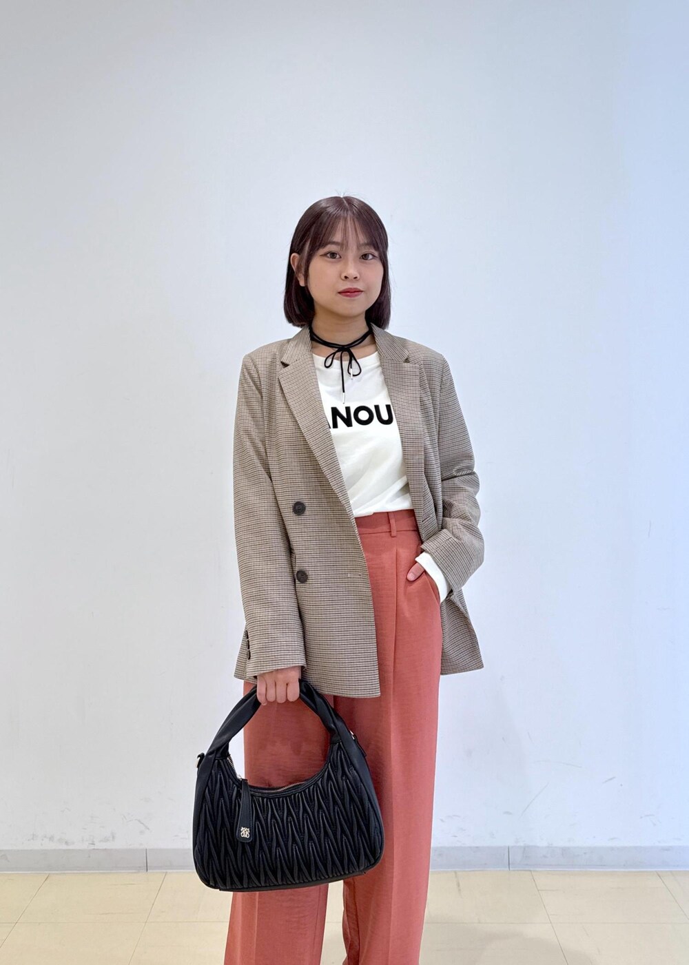 オレンジ系のスラックス、ベージュ系のテーラードジャケット、ホワイト系のTシャツ/カットソーを着用したレディースの秋コーディネートの5枚目の写真