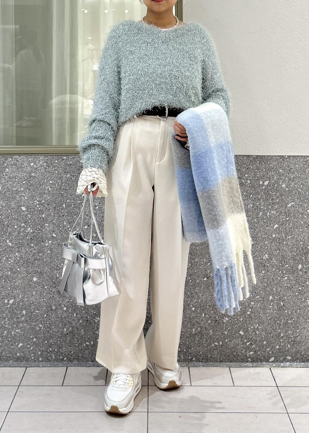 グリーン系のニット/セーター、ホワイト系のTシャツ/カットソー、シルバー系のショルダーバッグを着用したレディースの冬コーディネートの10枚目の写真