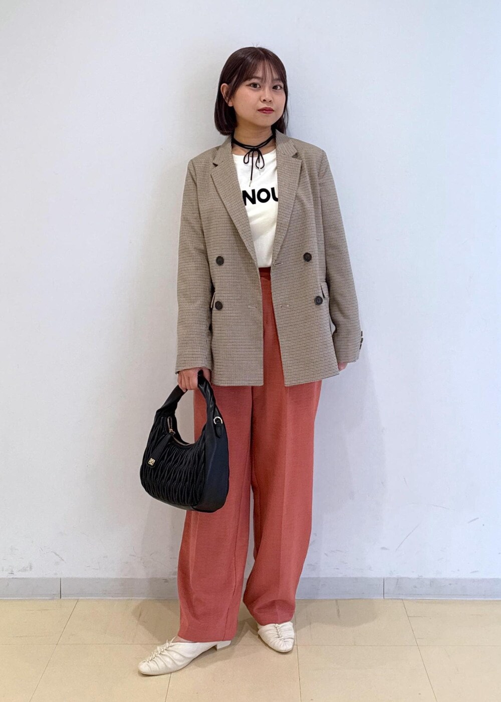 オレンジ系のスラックス、ベージュ系のテーラードジャケット、ホワイト系のTシャツ/カットソーを着用したレディースの秋コーディネートの8枚目の写真