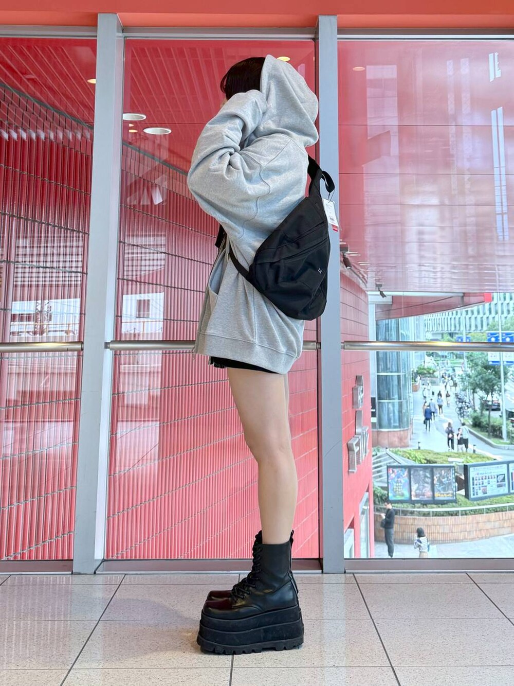 グレー系のパーカー、ブラック系のデニムスカートを着用したレディースの冬コーディネートの2枚目の写真