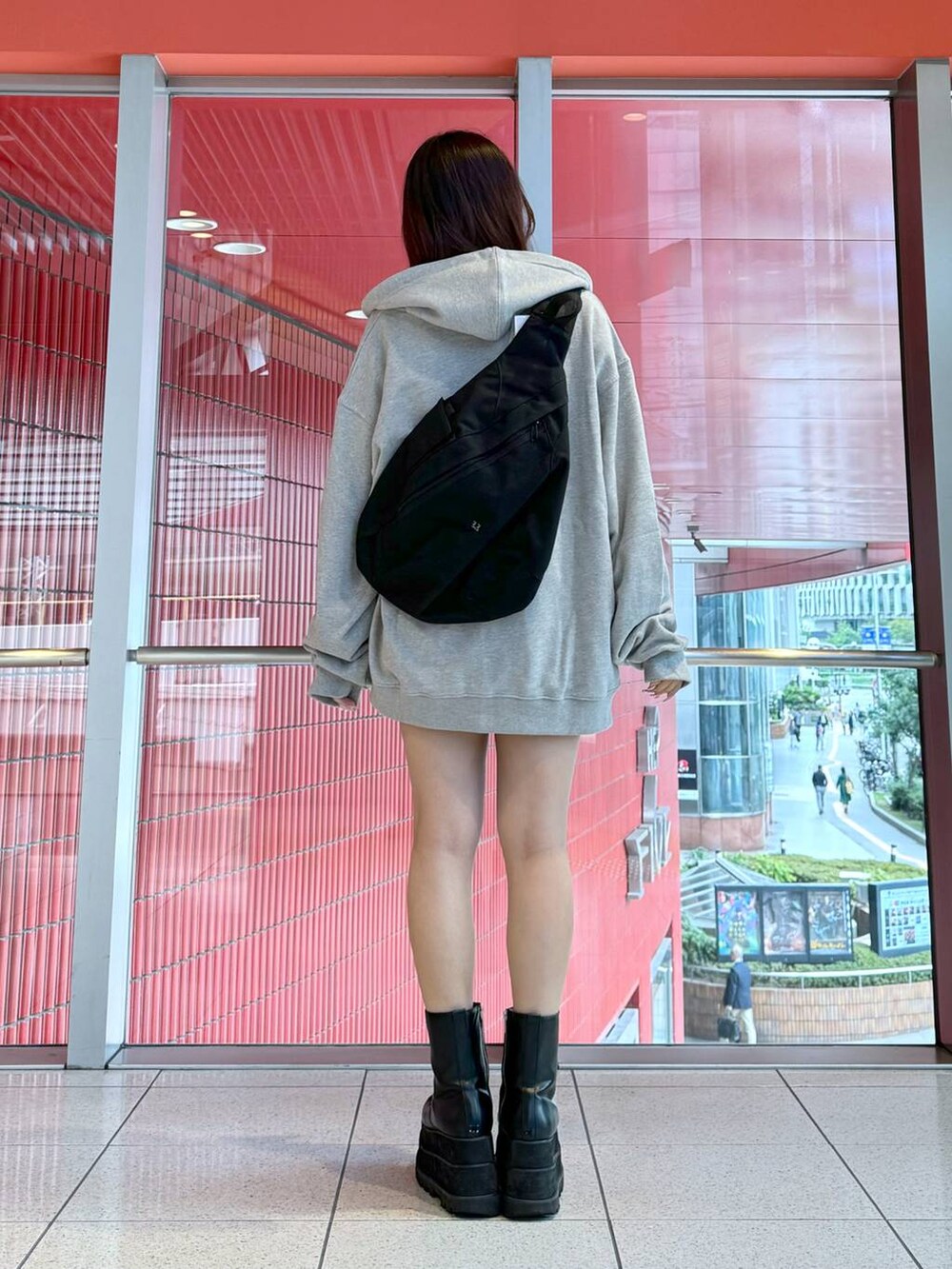 グレー系のパーカー、ブラック系のデニムスカートを着用したレディースの冬コーディネートの3枚目の写真