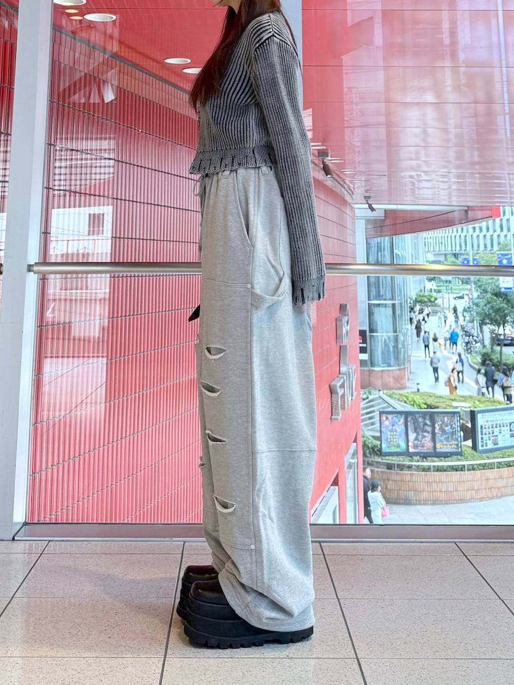 ブラック系のハンドバッグ、ブラック系のニット/セーター、グレー系のスウェットパンツを着用したレディースの秋コーディネートの2枚目の写真