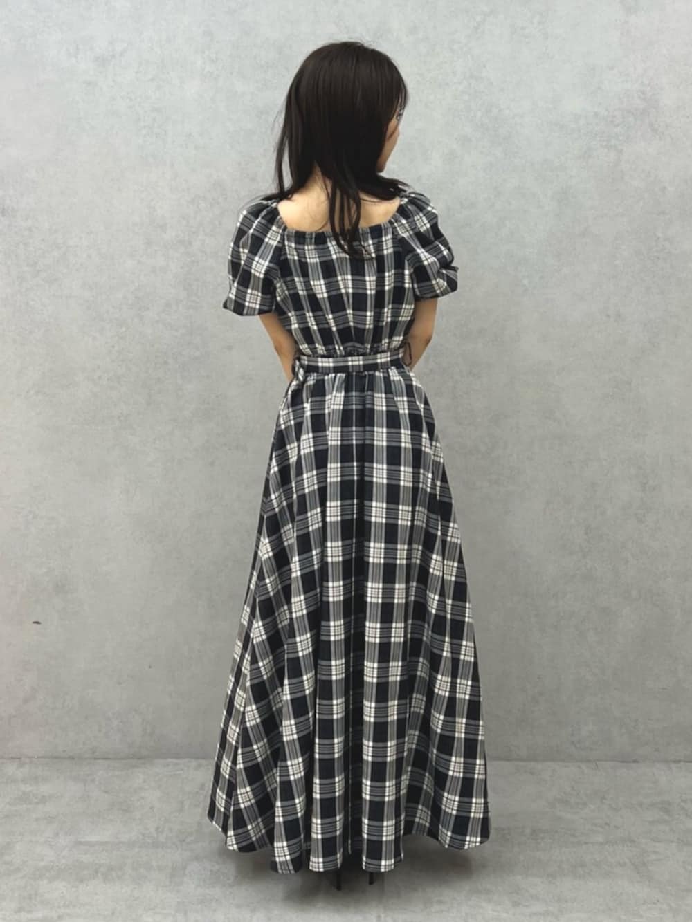 ブラック系のワンピース、ブラック系のパンプスを着用したレディースの夏コーディネートの3枚目の写真