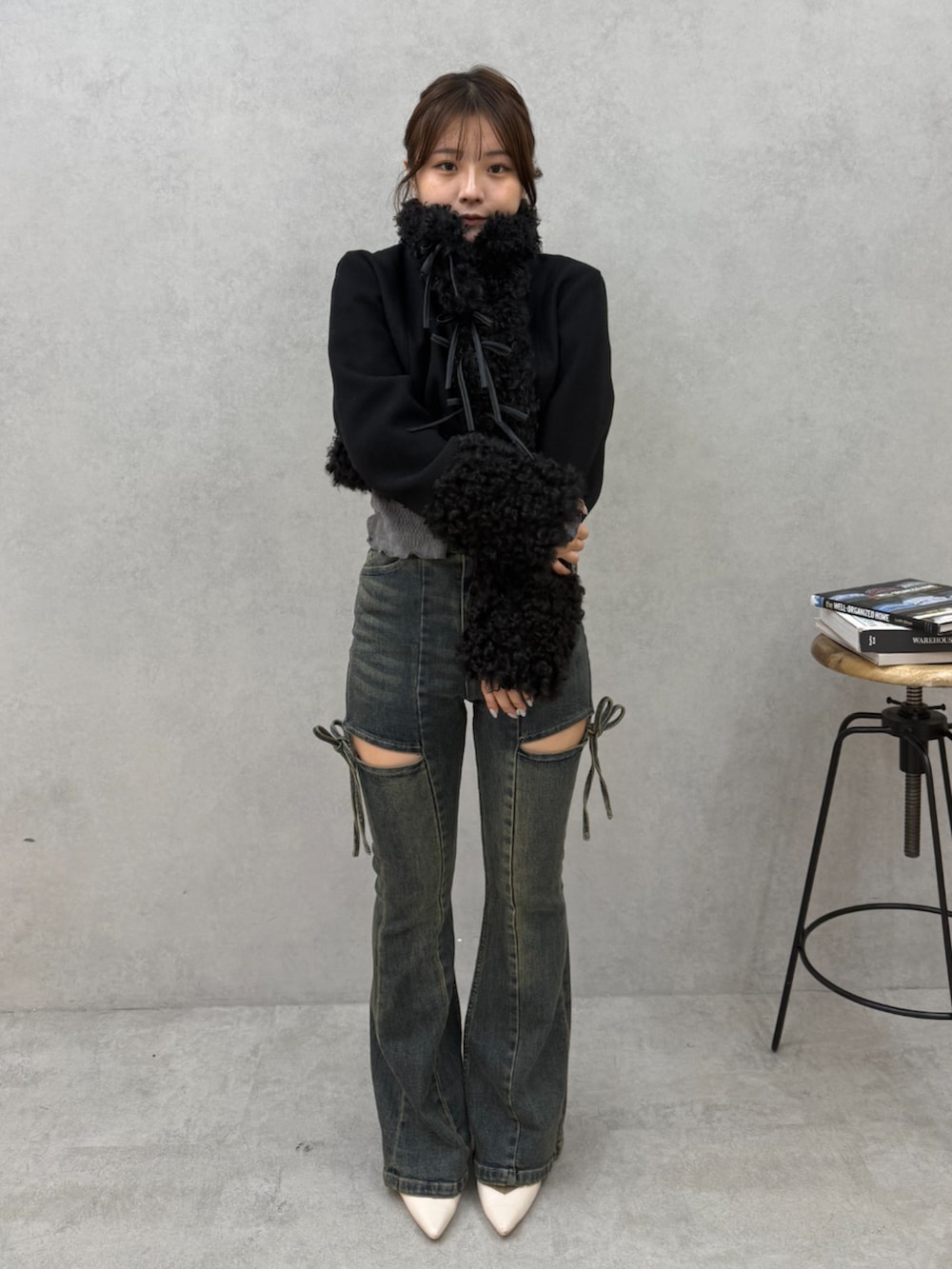 ブルー系のデニムパンツ、ブラック系のブルゾンを着用したレディースの秋コーディネートの4枚目の写真