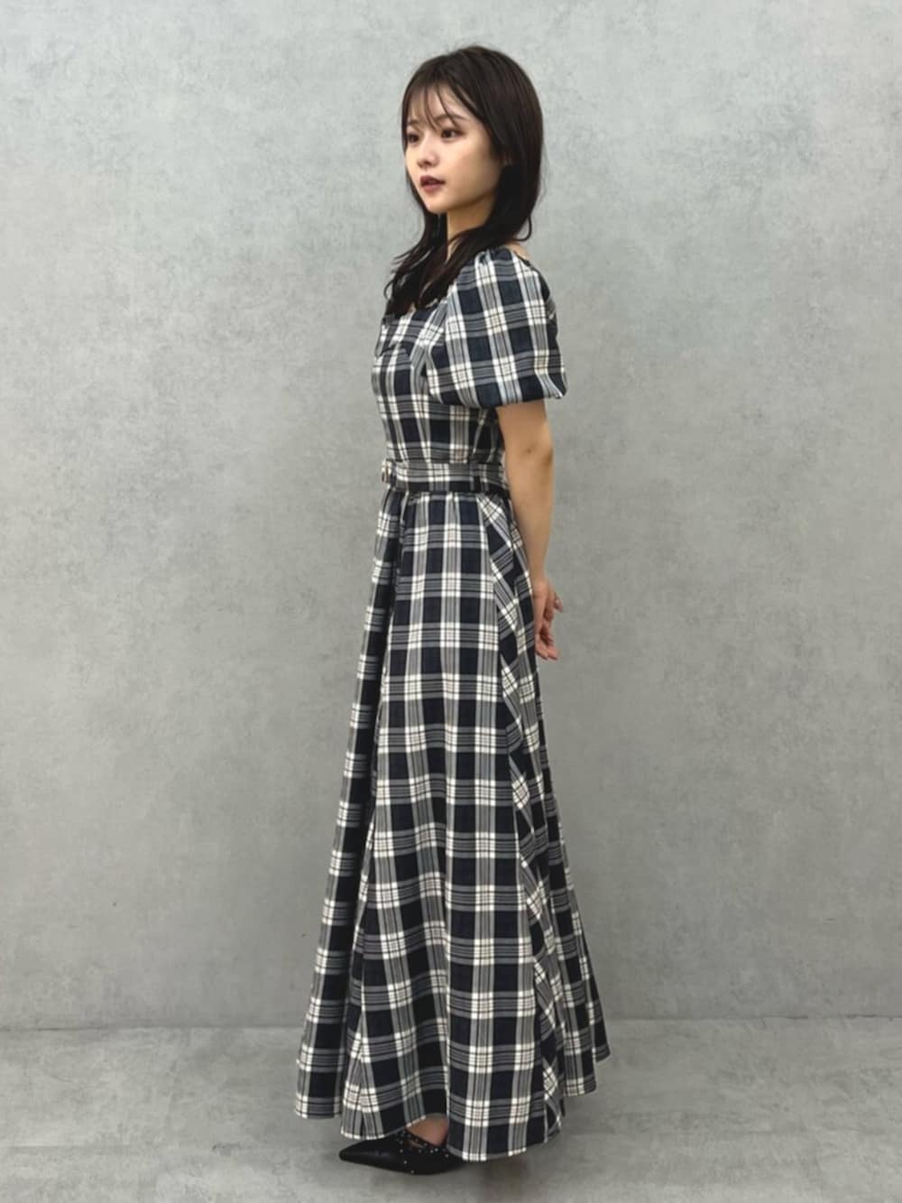 ブラック系のワンピース、ブラック系のパンプスを着用したレディースの夏コーディネートの2枚目の写真