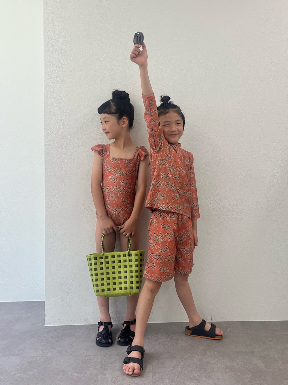 グリーン系のトートバッグ、オレンジ系の水着、オレンジ系の水着を着用したキッズの夏コーディネートの2枚目の写真