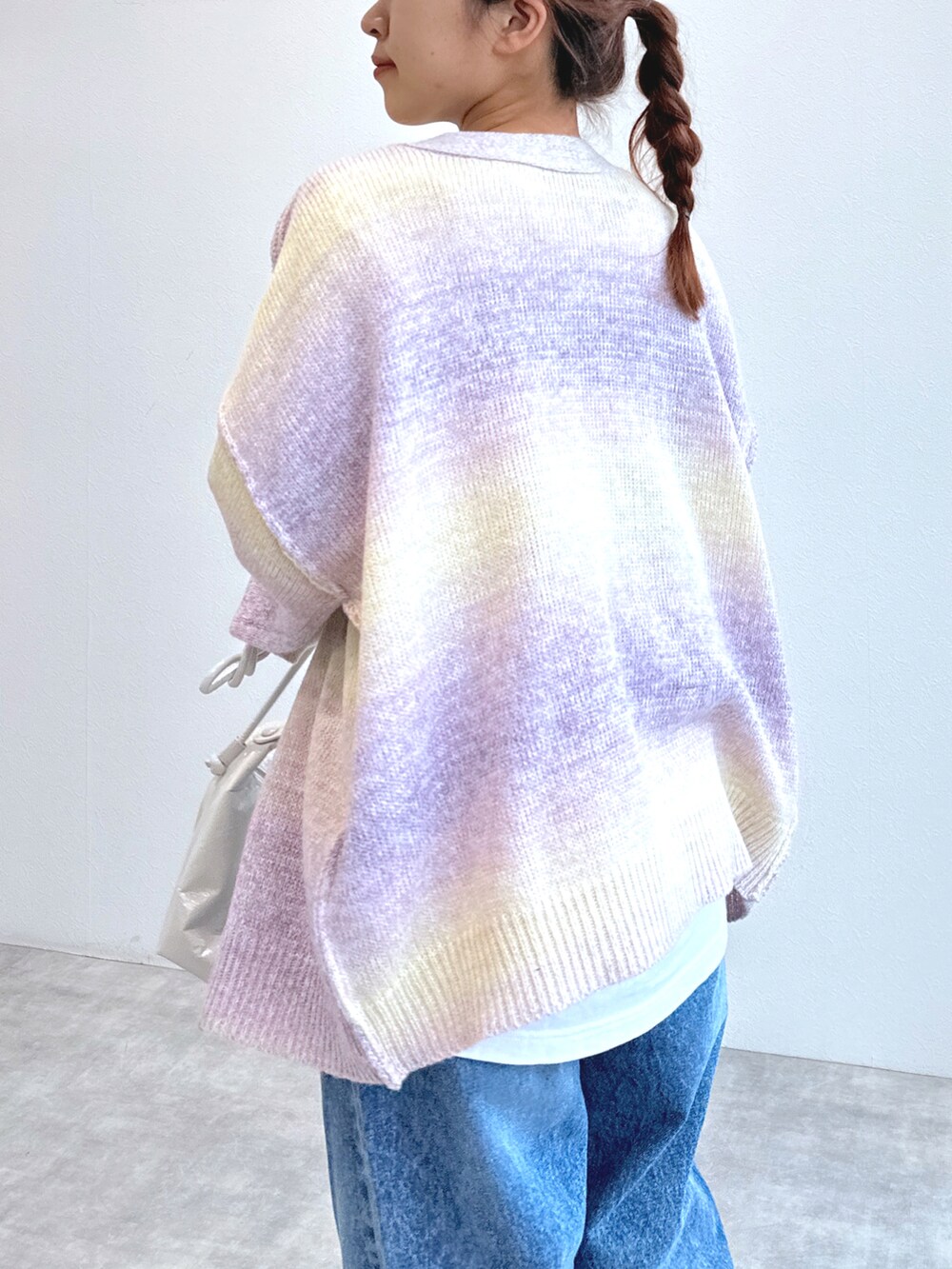 ブルー系のデニムパンツ、ホワイト系のTシャツ/カットソー、ピンク系のカーディガン/ボレロを着用したレディースの冬コーディネートの4枚目の写真