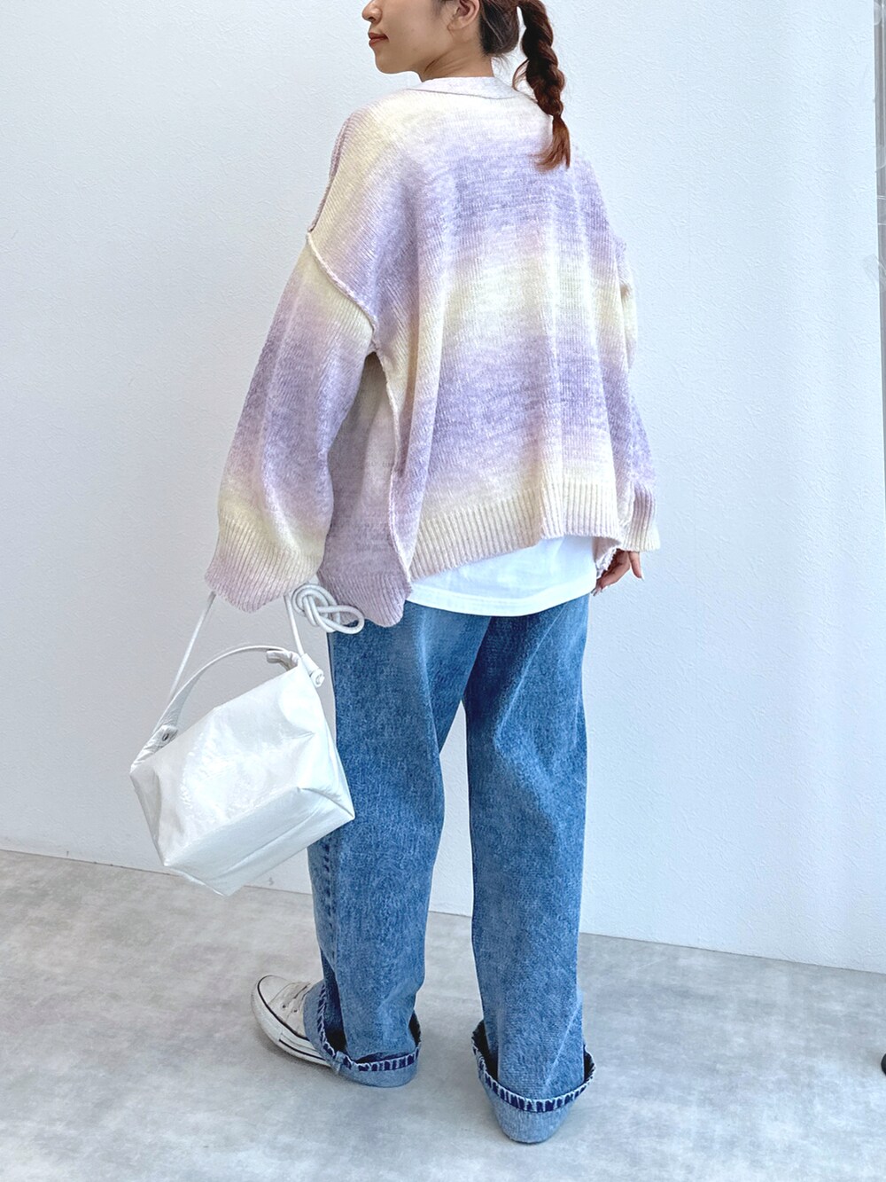 ブルー系のデニムパンツ、ホワイト系のTシャツ/カットソー、ピンク系のカーディガン/ボレロを着用したレディースの冬コーディネートの3枚目の写真