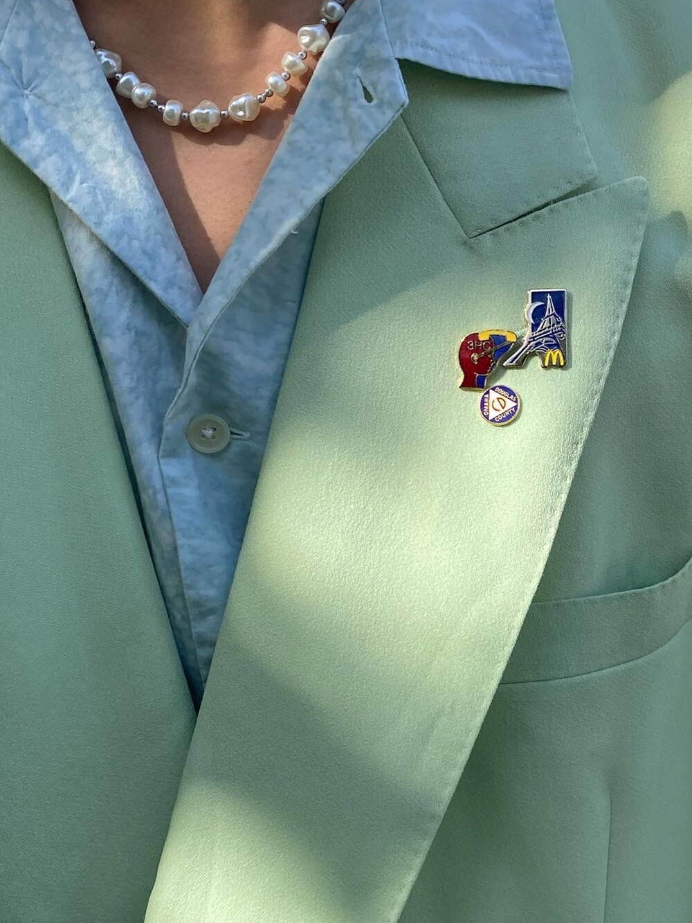 グリーン系のテーラードジャケット、ブルー系のシャツ/ブラウス、ブラウン系のハンドバッグを着用したメンズの春コーディネートの3枚目の写真