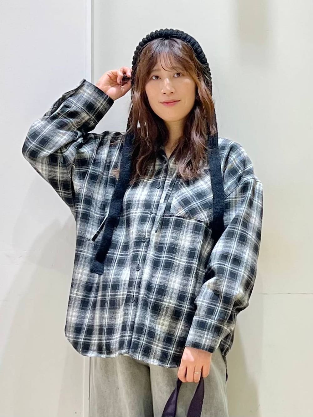 ブラック系のブルゾン、グレー系のデニムパンツ、ブラック系のブーツを着用したレディースの秋コーディネートの4枚目の写真
