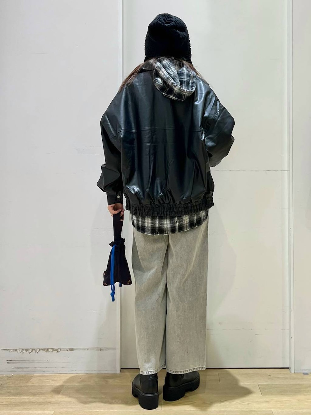 ブラック系のブルゾン、グレー系のデニムパンツ、ブラック系のブーツを着用したレディースの秋コーディネートの3枚目の写真
