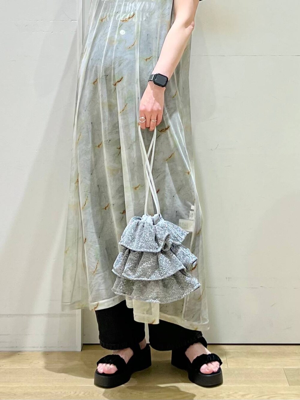 シルバー系のショルダーバッグ、ブラック系のデニムパンツ、グレー系のTシャツ/カットソーを着用したレディースの春コーディネートの5枚目の写真