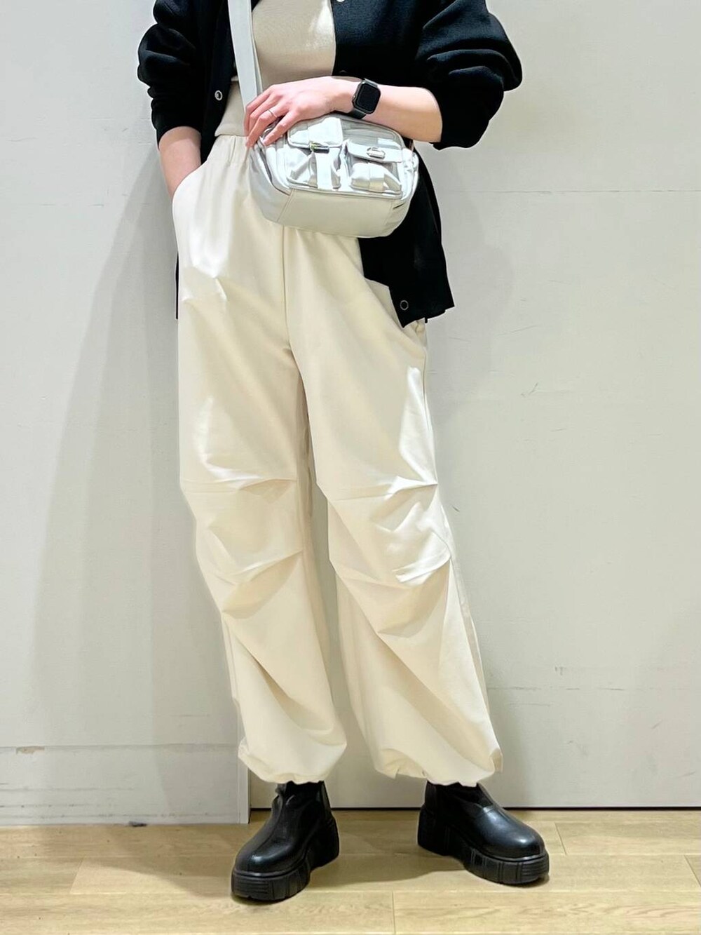 ベージュ系のその他パンツ、イエロー系のニット/セーター、ブラック系のブーツを着用したレディースの冬コーディネートの5枚目の写真