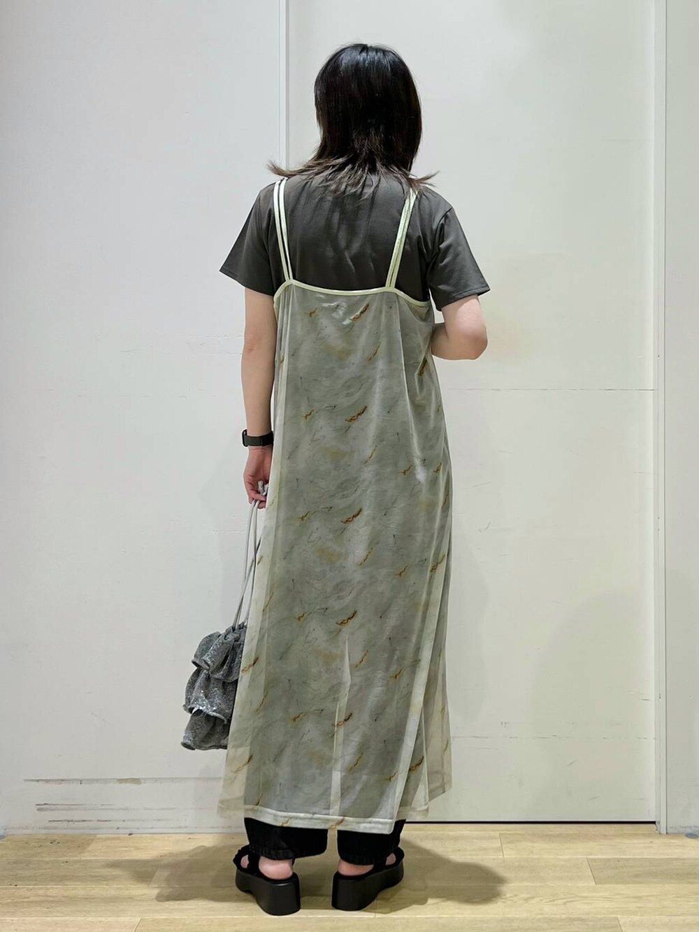 シルバー系のショルダーバッグ、ブラック系のデニムパンツ、グレー系のTシャツ/カットソーを着用したレディースの春コーディネートの3枚目の写真