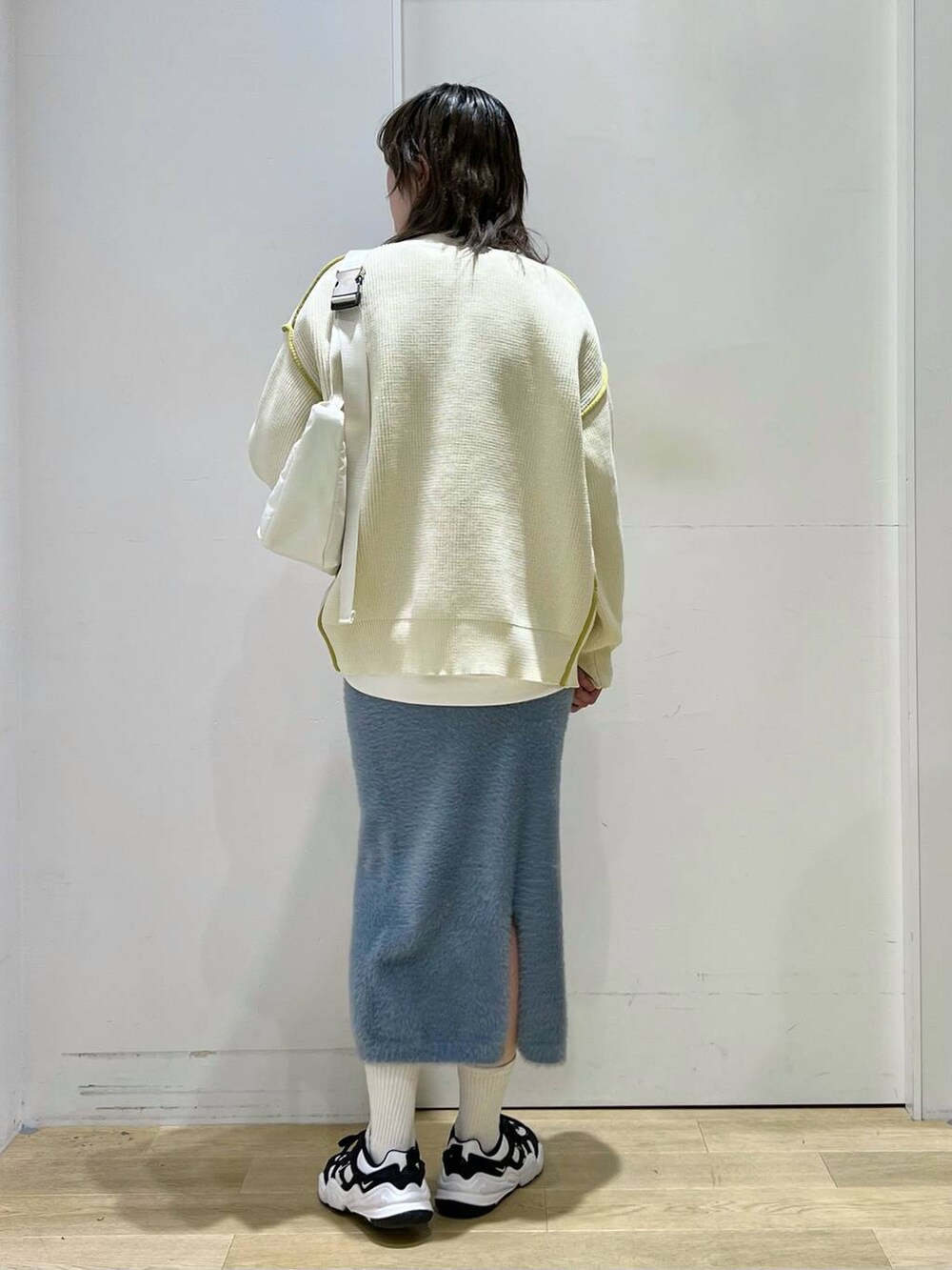 ホワイト系のショルダーバッグ、ブルー系のスカート、ホワイト系のカーディガン/ボレロを着用したレディースの冬コーディネートの3枚目の写真