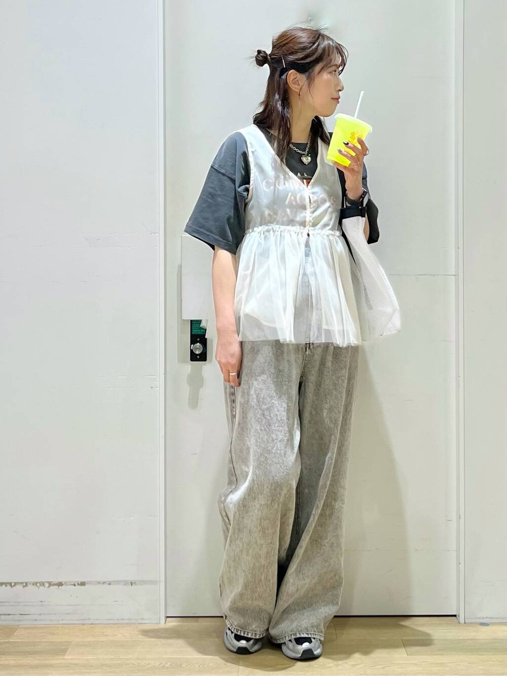 グレー系のデニムパンツ、ベージュ系のベスト、グレー系のTシャツ/カットソーを着用したレディースの春コーディネートの6枚目の写真