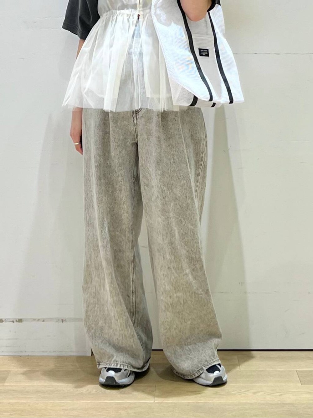 グレー系のデニムパンツ、ベージュ系のベスト、グレー系のTシャツ/カットソーを着用したレディースの春コーディネートの5枚目の写真