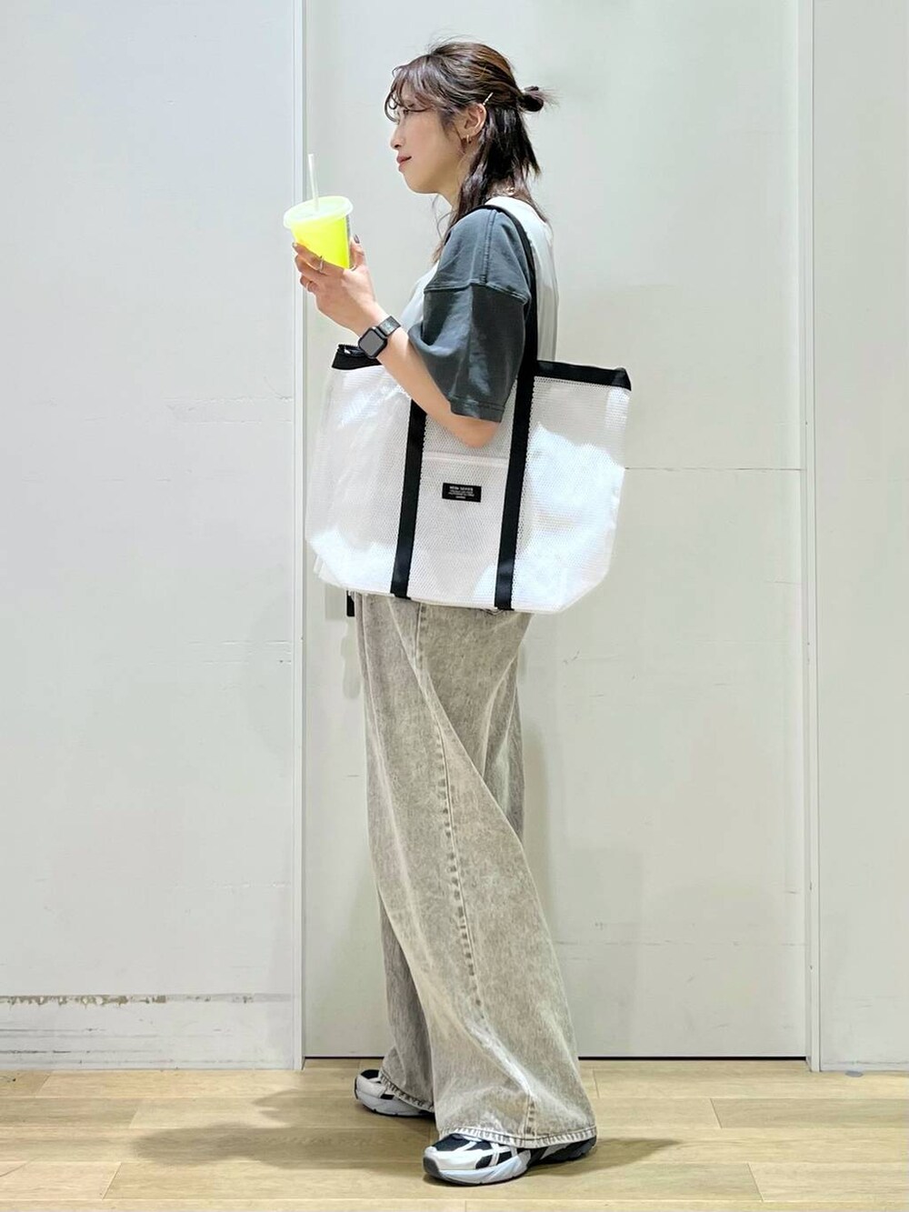 グレー系のデニムパンツ、ベージュ系のベスト、グレー系のTシャツ/カットソーを着用したレディースの春コーディネートの2枚目の写真