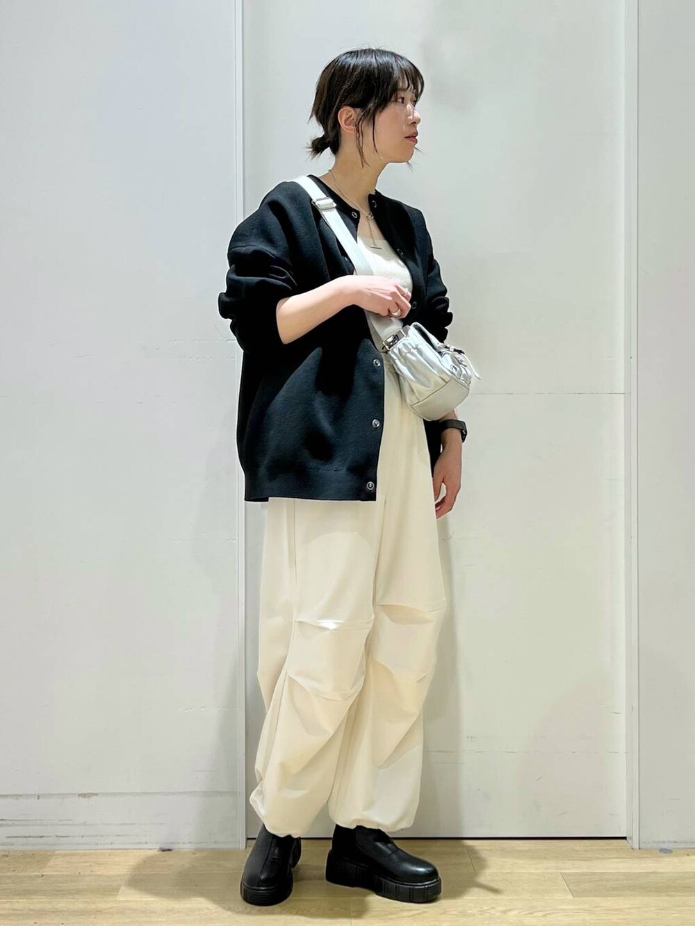 ベージュ系のその他パンツ、イエロー系のニット/セーター、ブラック系のブーツを着用したレディースの冬コーディネートの6枚目の写真