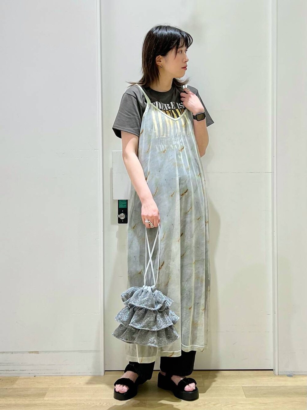 シルバー系のショルダーバッグ、ブラック系のデニムパンツ、グレー系のTシャツ/カットソーを着用したレディースの春コーディネートの6枚目の写真