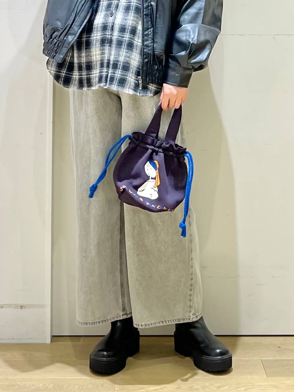 ブラック系のブルゾン、グレー系のデニムパンツ、ブラック系のブーツを着用したレディースの秋コーディネートの5枚目の写真