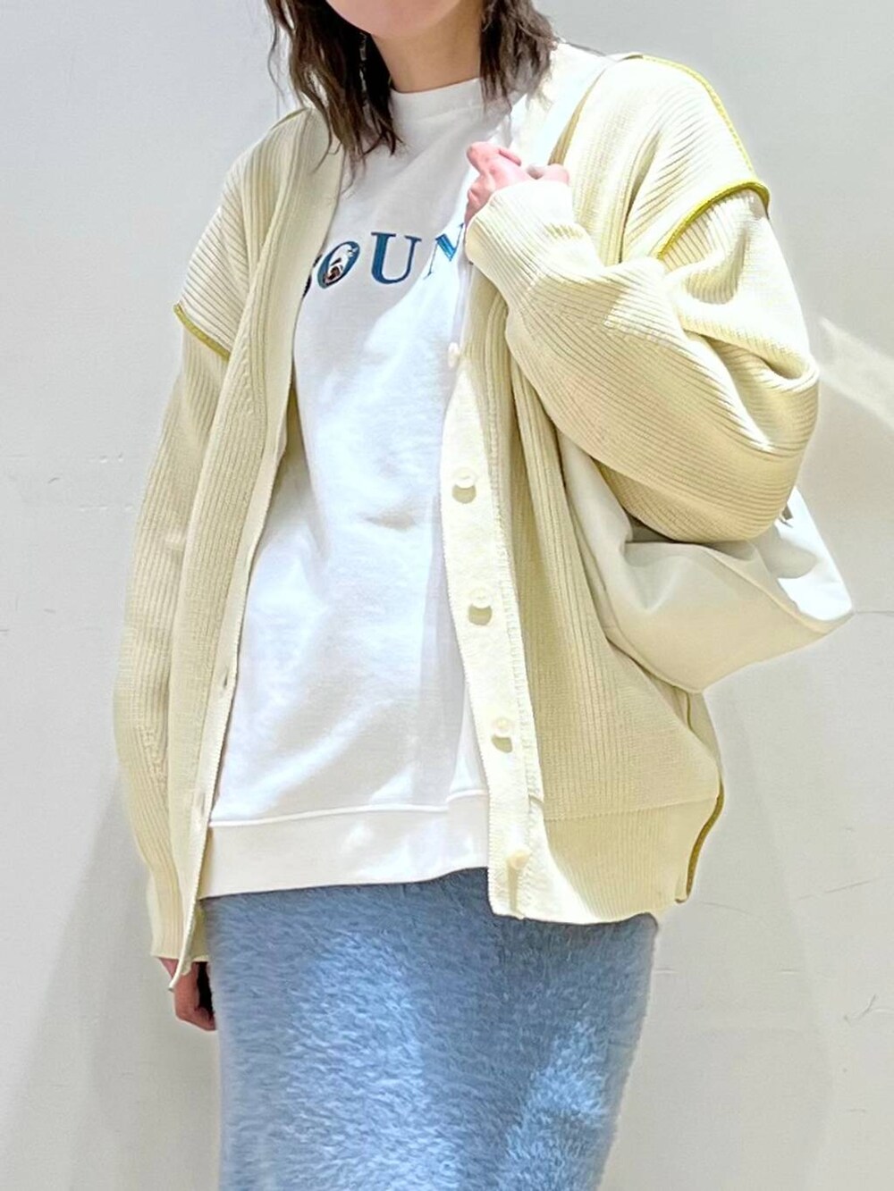 ホワイト系のショルダーバッグ、ブルー系のスカート、ホワイト系のカーディガン/ボレロを着用したレディースの冬コーディネートの4枚目の写真