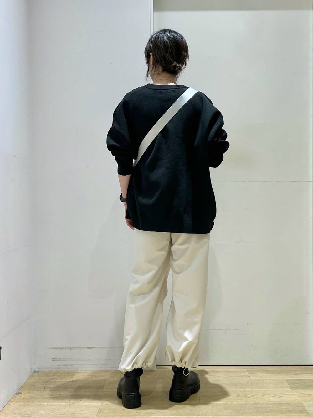ベージュ系のその他パンツ、イエロー系のニット/セーター、ブラック系のブーツを着用したレディースの冬コーディネートの3枚目の写真