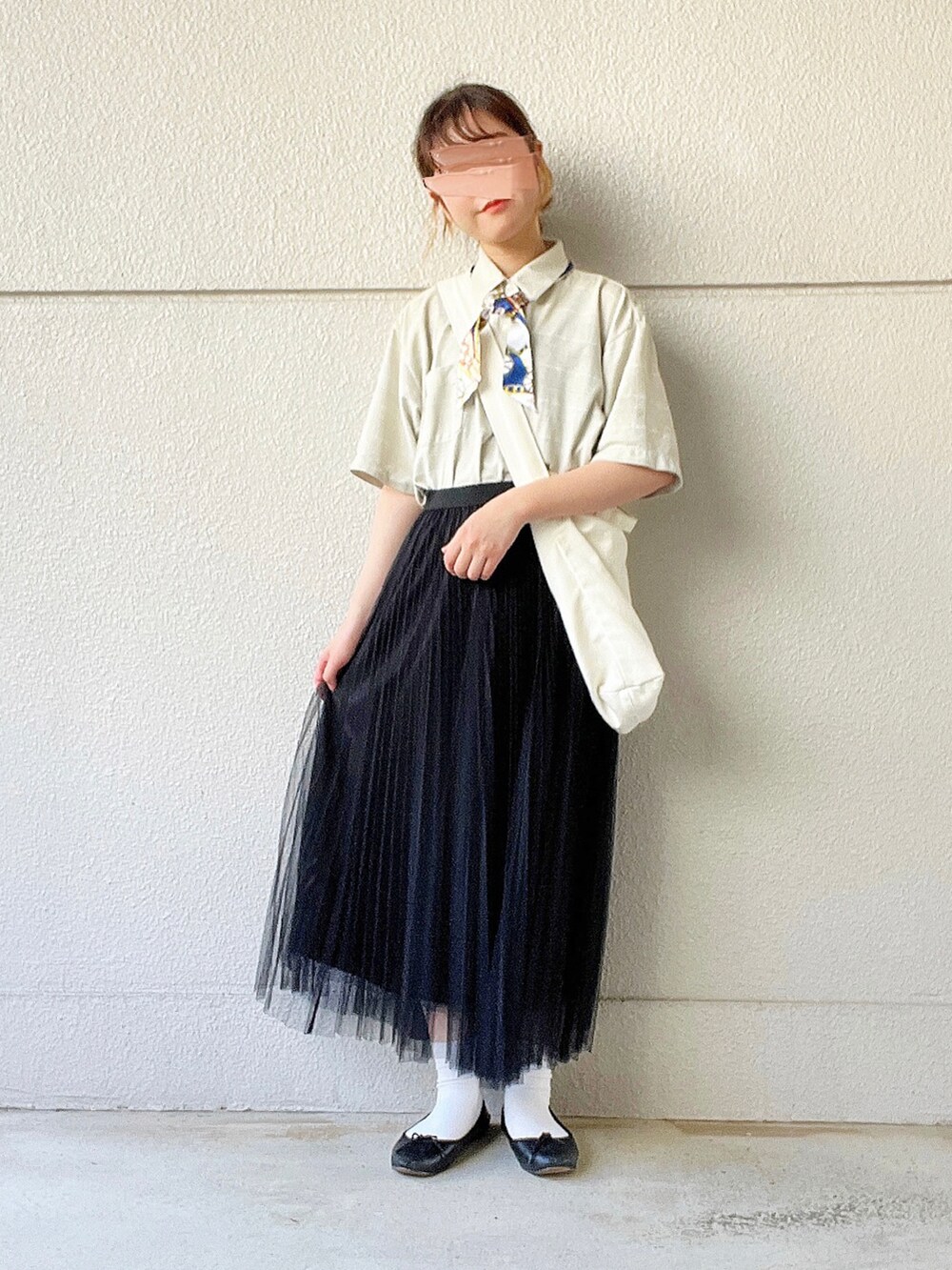 グリーン系のポロシャツ、ブラック系のスカート、ホワイト系のショルダーバッグを着用したレディースの秋コーディネートの2枚目の写真