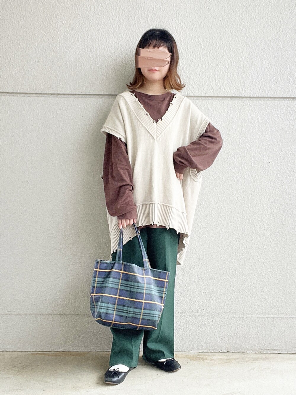 ブラウン系のTシャツ/カットソー、ベージュ系のベスト、グリーン系のスラックスを着用したレディースの冬コーディネートの2枚目の写真