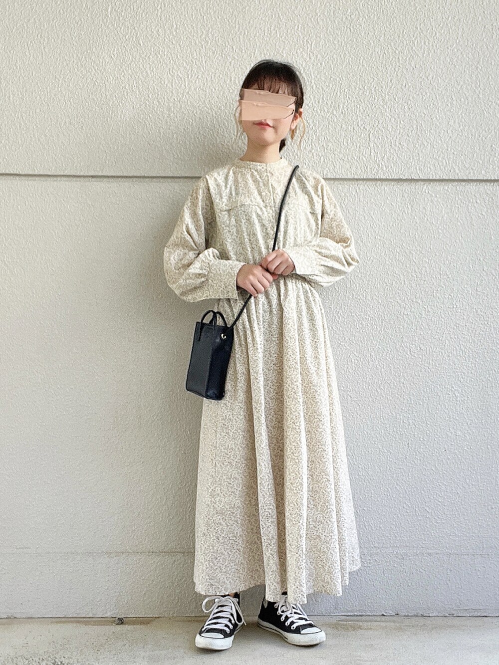 ホワイト系のワンピース、ブラック系のバッグ、ブラック系のスニーカーを着用したレディースの秋コーディネートの3枚目の写真