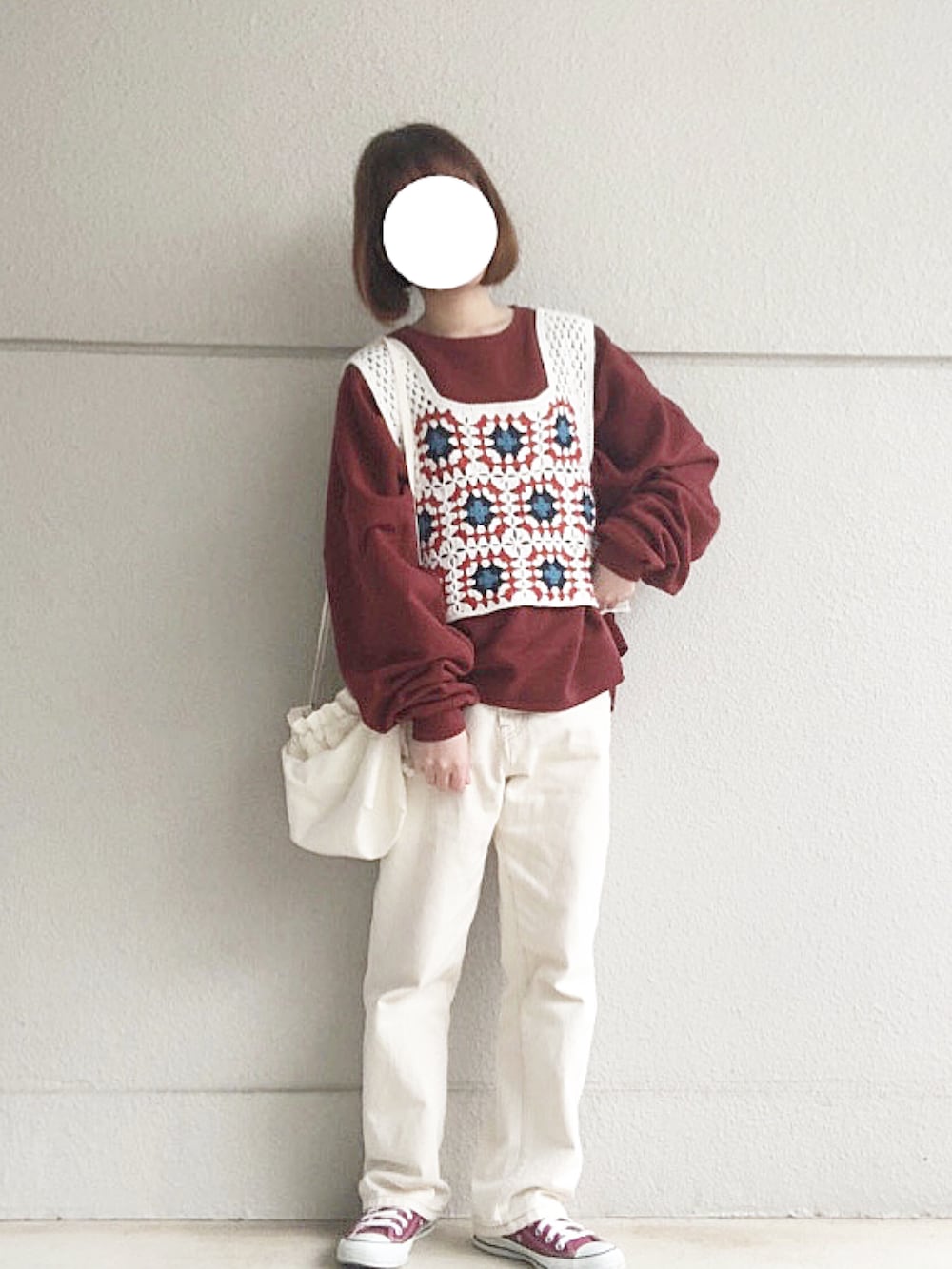 レッド系のスウェット、ホワイト系のニット/セーター、ホワイト系のデニムパンツを着用したレディースの冬コーディネートの2枚目の写真