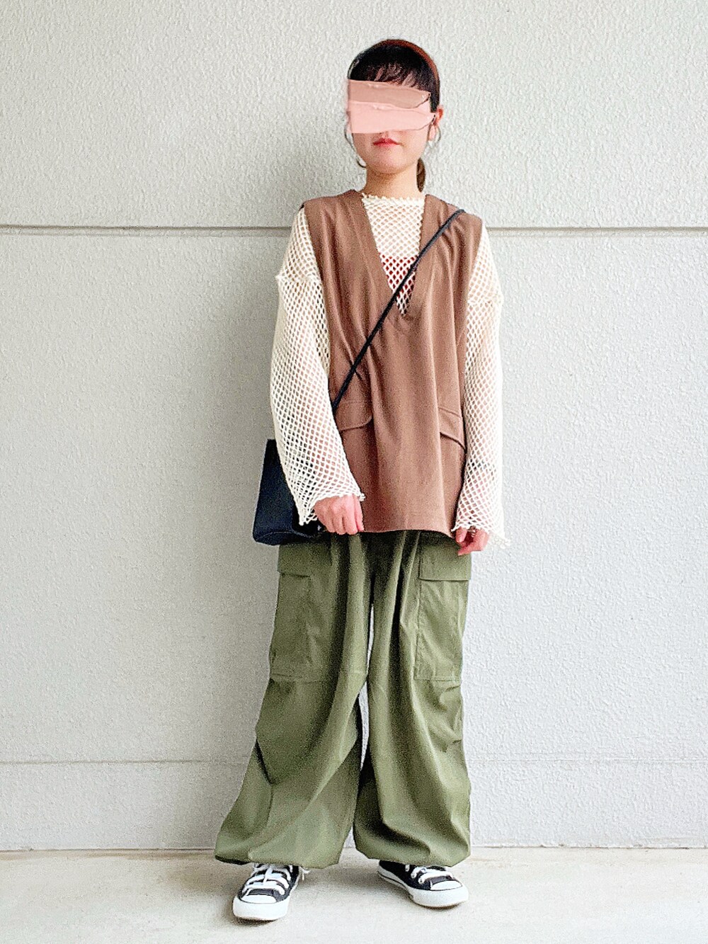 ホワイト系のTシャツ/カットソー、ブラウン系のベスト、グリーン系のカーゴパンツを着用したレディースの春コーディネートの2枚目の写真