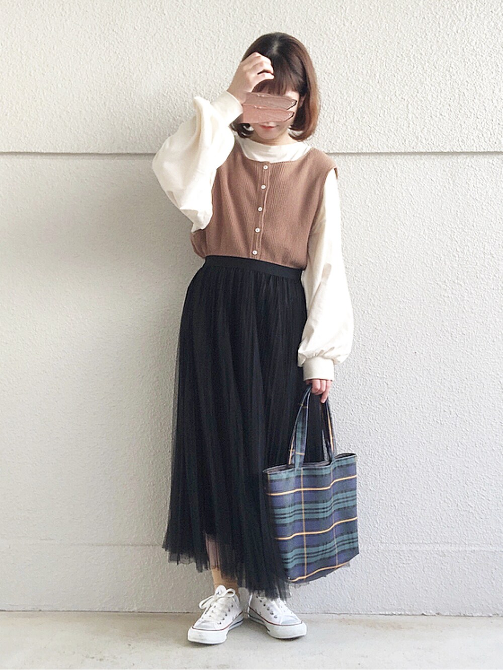 ベージュ系のTシャツ/カットソー、ブラック系のスカート、ブラウン系のベストを着用したレディースの冬コーディネートの2枚目の写真