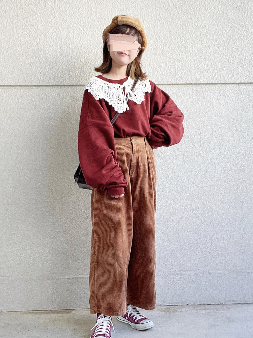 レッド系のスウェット、ブラウン系のその他パンツ、ブラウン系のショルダーバッグを着用したレディースの冬コーディネートの2枚目の写真