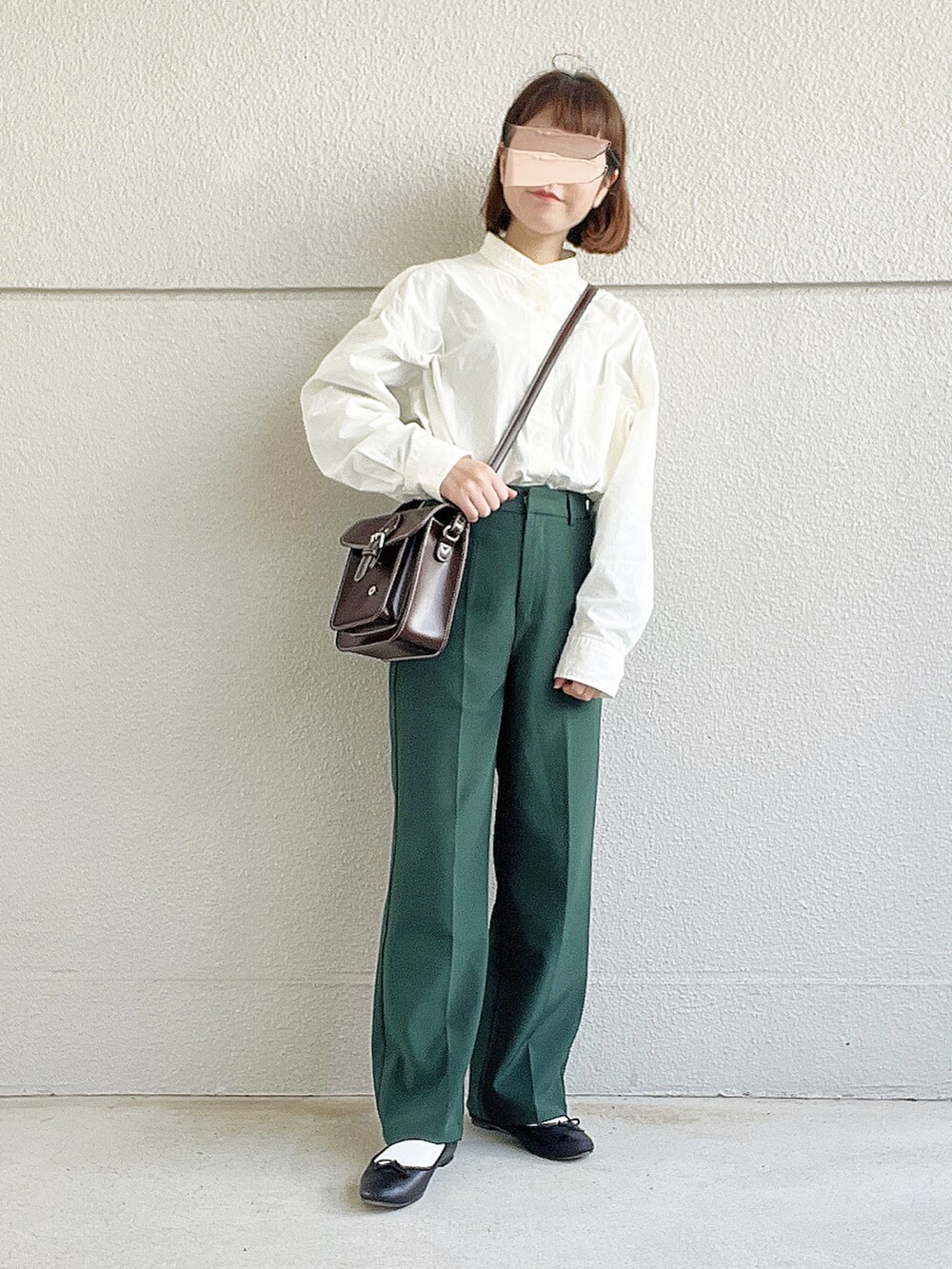 ホワイト系のシャツ/ブラウス、グリーン系のスラックス、ブラウン系のショルダーバッグを着用したレディースの春コーディネートの2枚目の写真