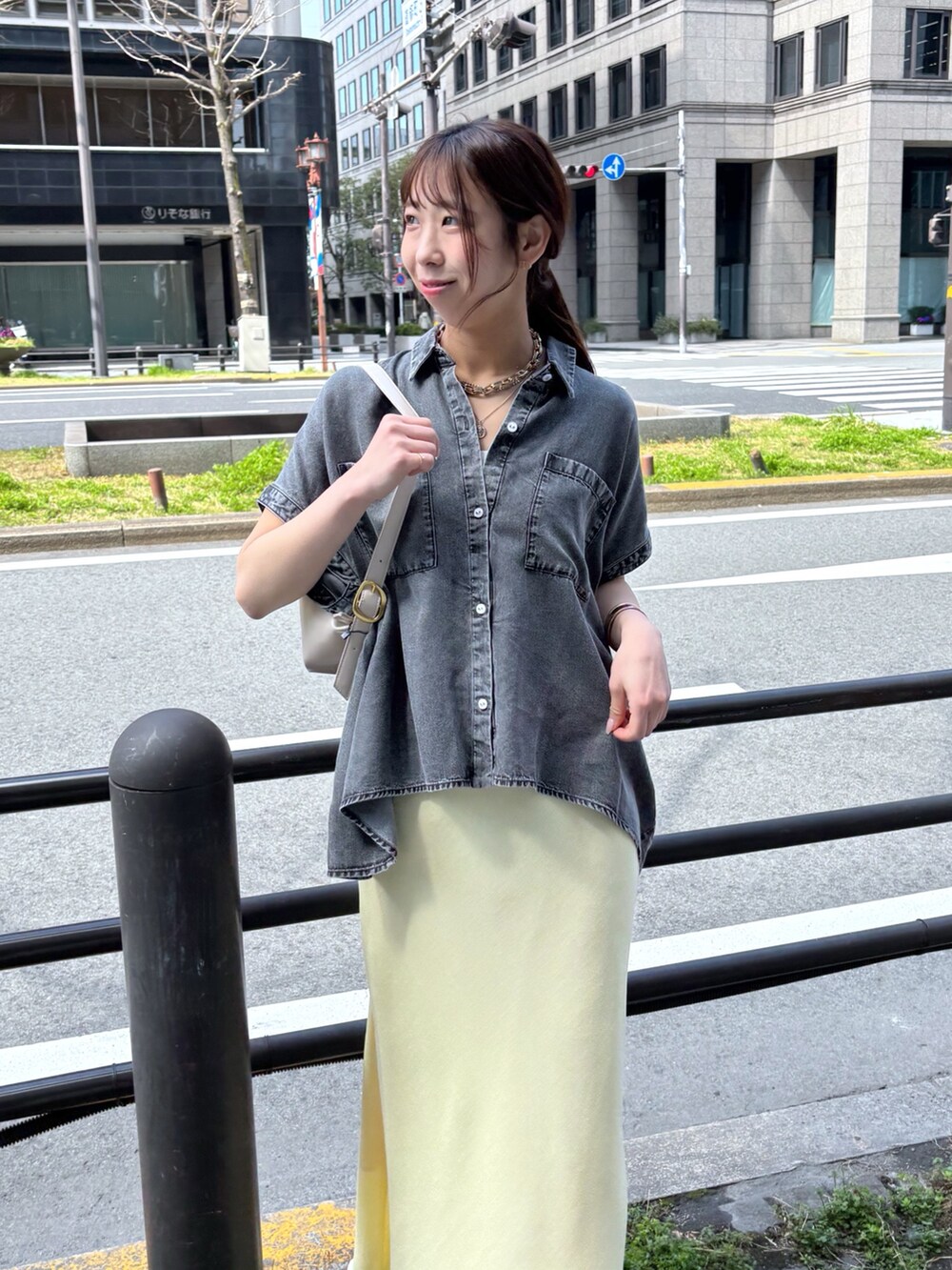 イエロー系のスカート、ブラック系のシャツ/ブラウスを着用したレディースの春コーディネートの3枚目の写真