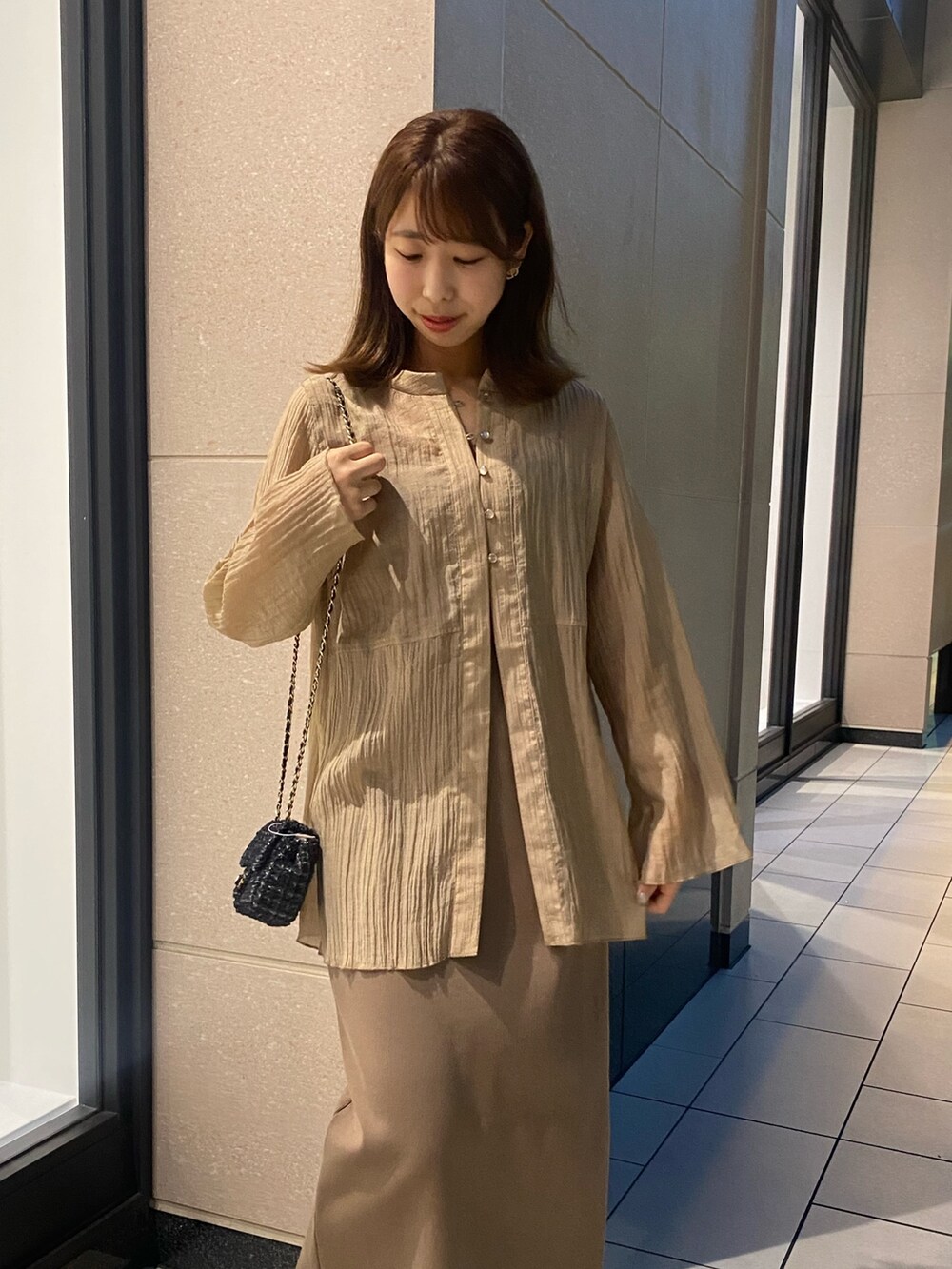 ベージュ系のワンピース、ブラック系のトートバッグを着用したレディースの夏コーディネートの3枚目の写真