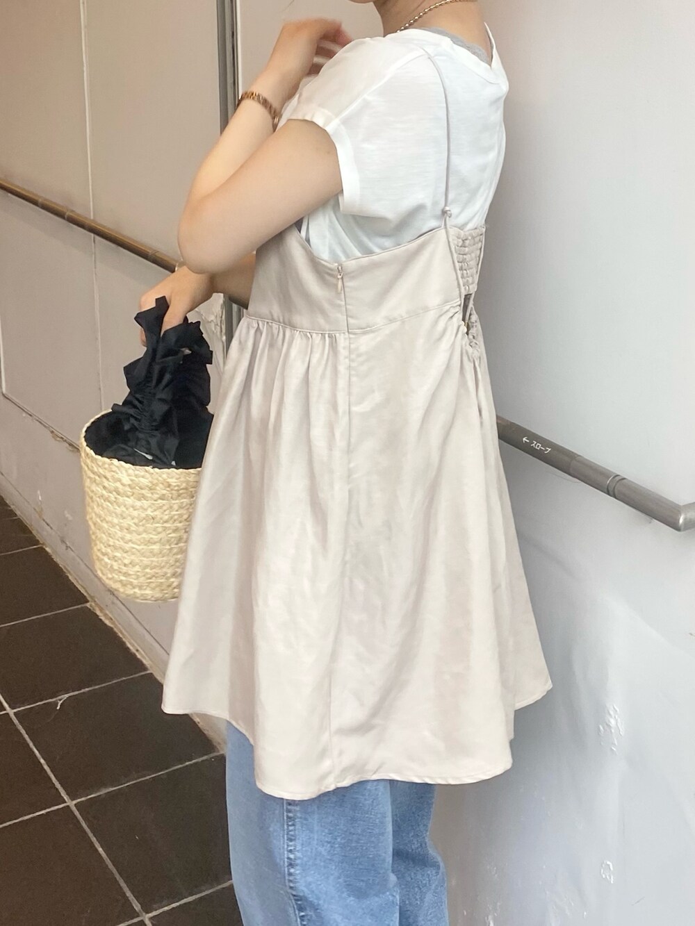 ベージュ系のキャミソール、ブルー系のデニムパンツ、ブラウン系のサンダルを着用したレディースの春コーディネートの4枚目の写真